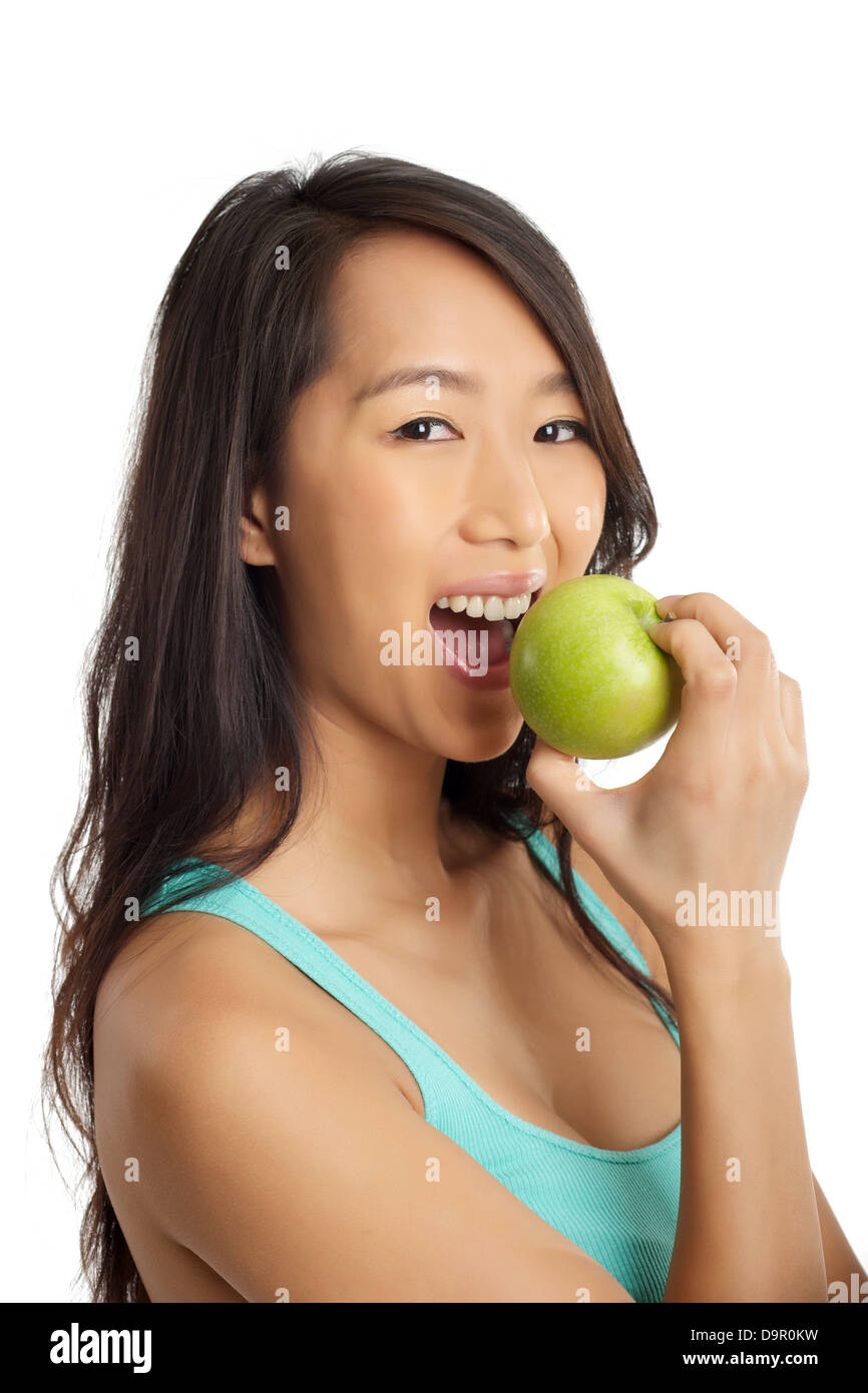 Beautiful Asian woman smiling and biting an apple Stock Photo