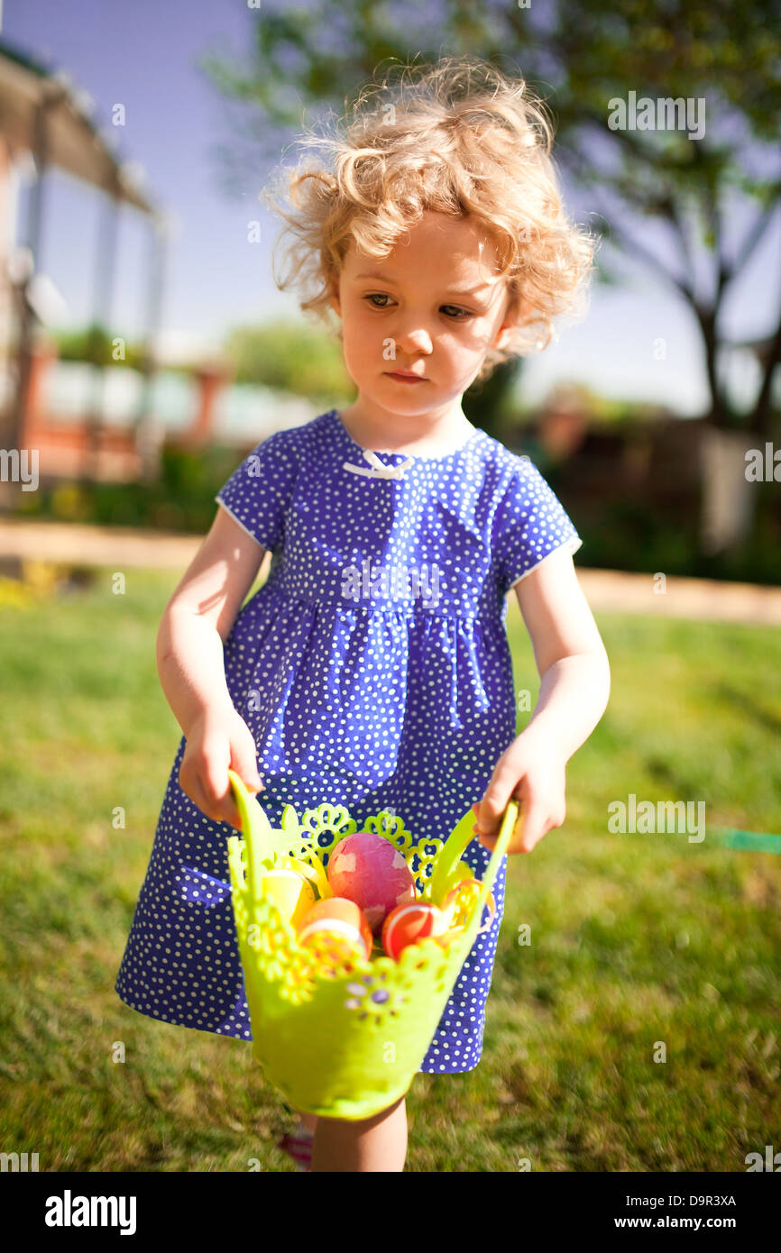 Little Girl on an Easter Egg hunt on a meadow in spring Stock Photo