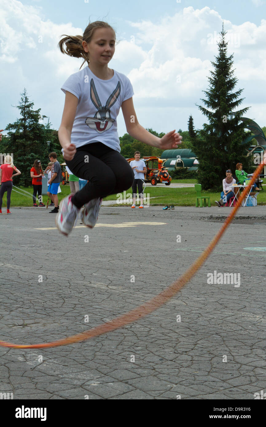 Girl jumping over a skipping rope Stock Photo - Alamy