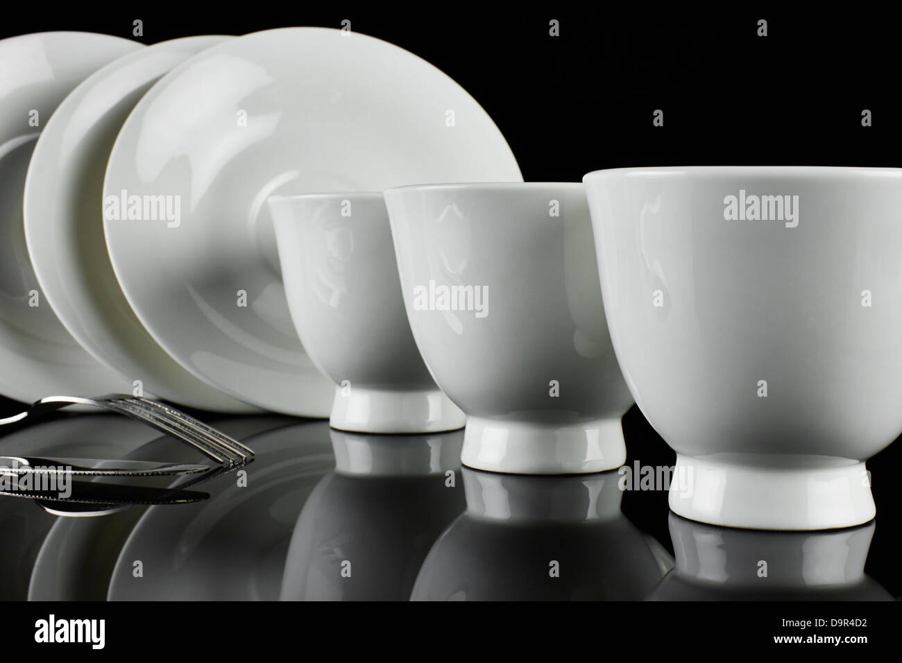 Cups and plates with cutlery on a table Stock Photo Alamy