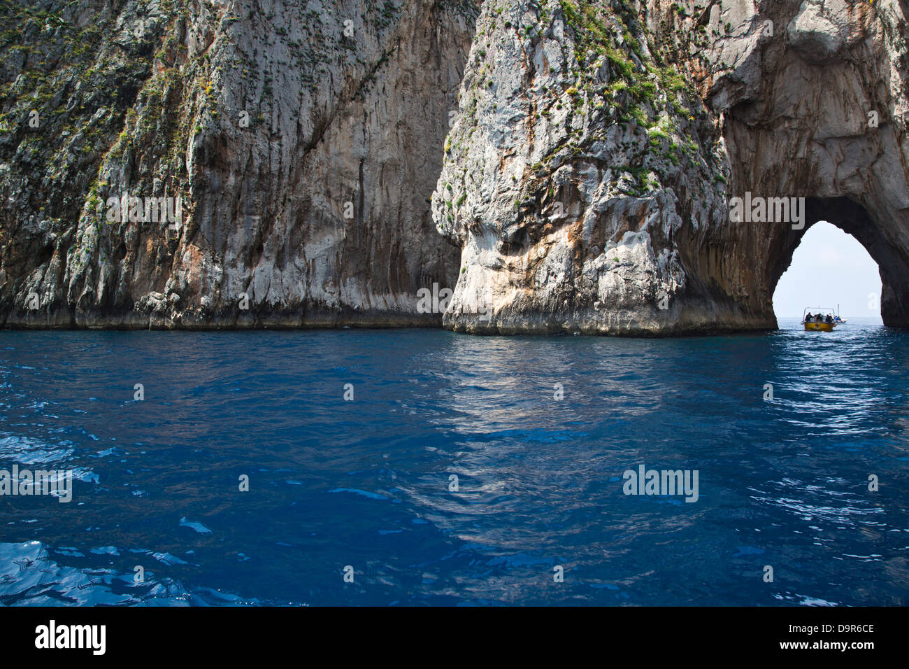 Boat passing through a natural arch, Capri, Naples Province, Campania, Italy Stock Photo