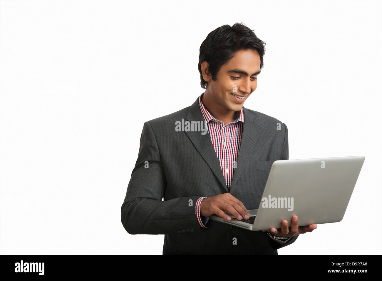 Businessman using a laptop and smiling Stock Photo