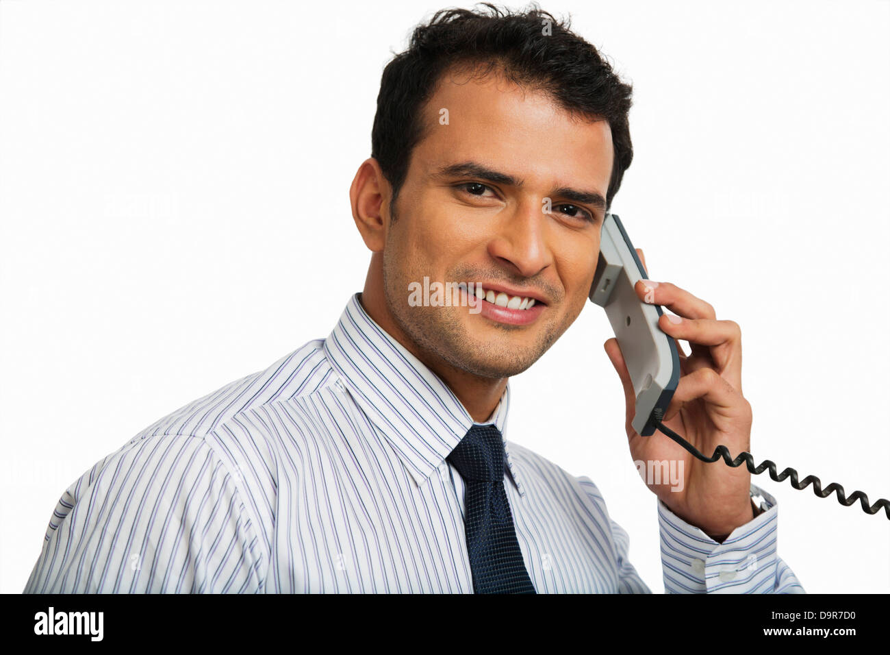 Businessman talking on a landline phone and smiling Stock Photo