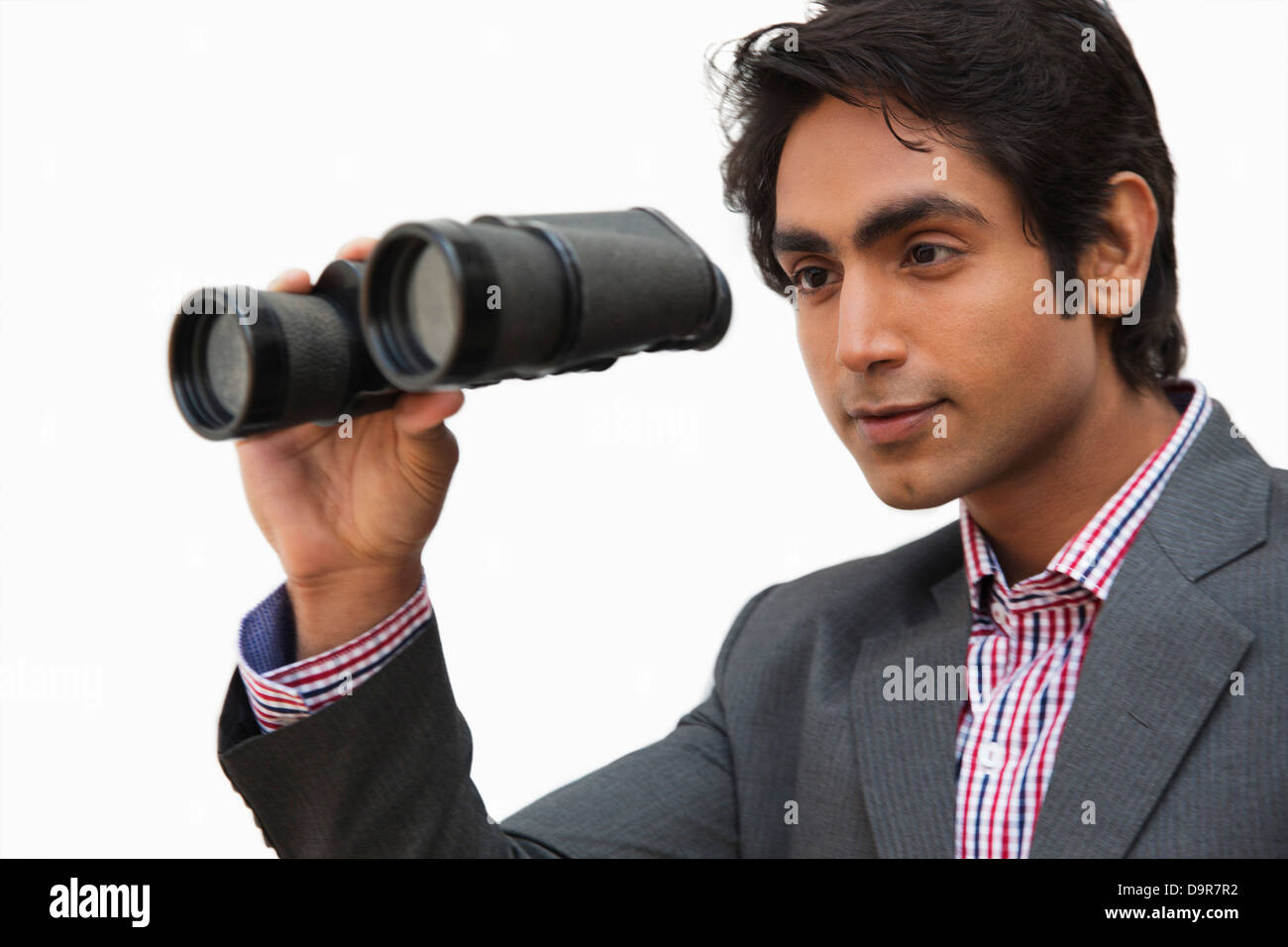 Businessman looking through binoculars Stock Photo