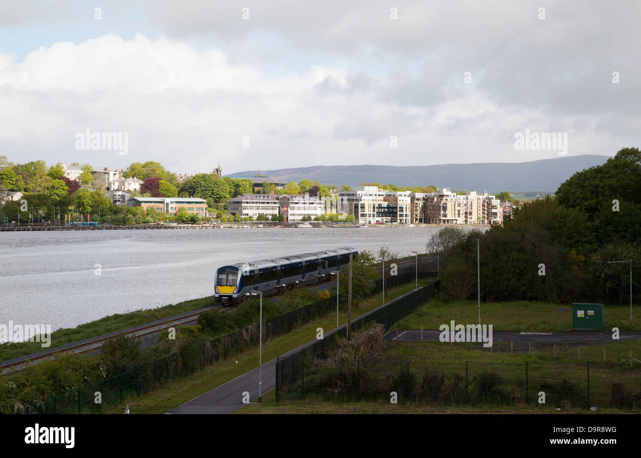 Belfast train leaving Derry Londonderry with Derry Council building in background Derry Londonderry Northern Ireland Stock Photo