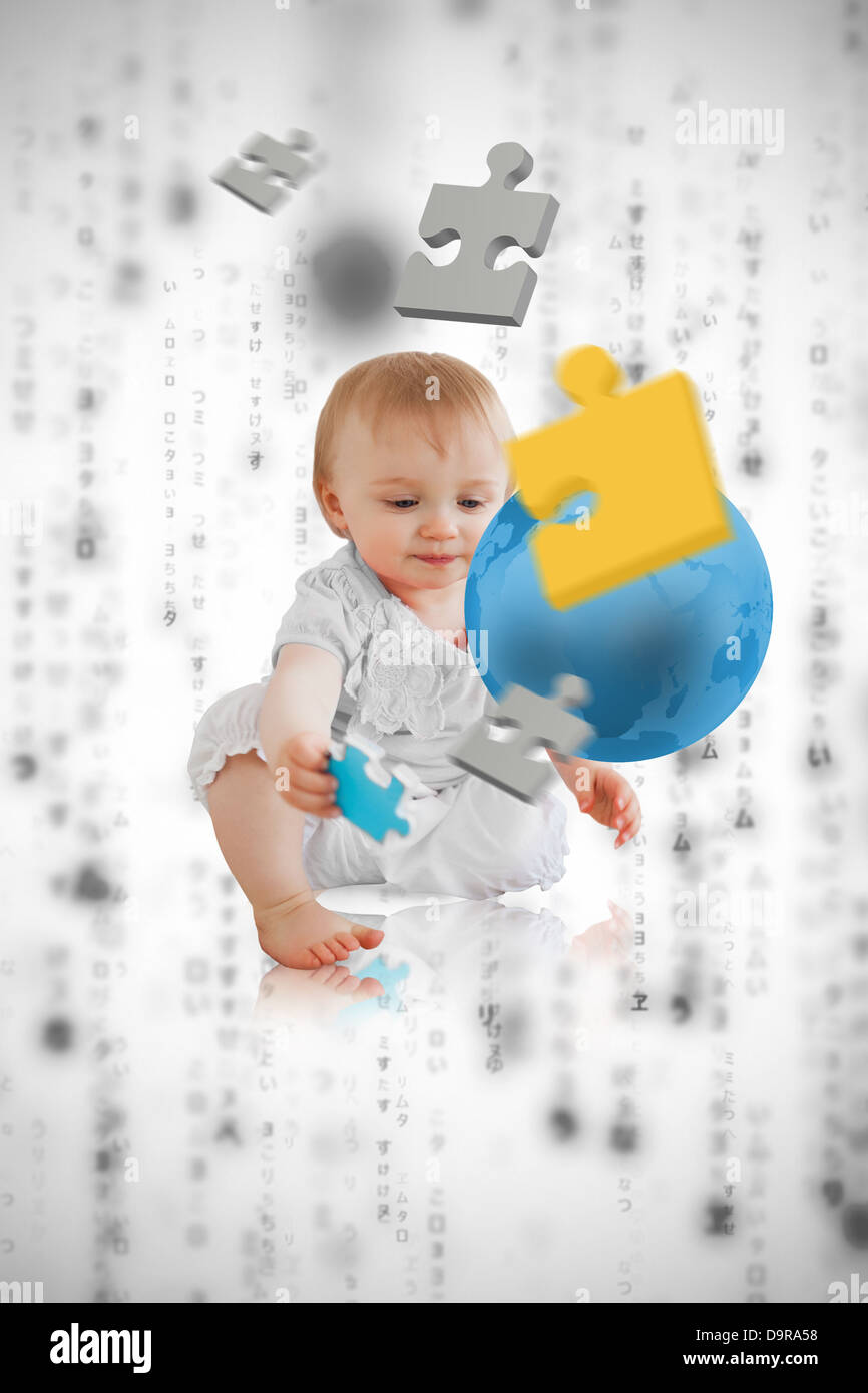 Jigsaw pieces floating around a cute baby playing with a blue planet Stock Photo