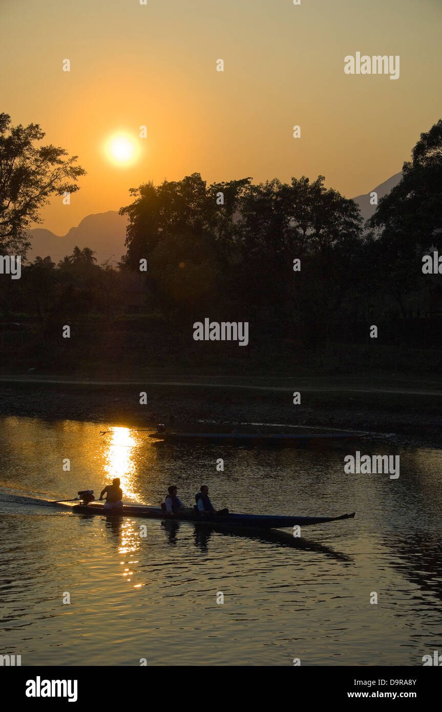 Vertical view of a motor boat travelling down the Nam Song river in Vang Vieng at sunet. Stock Photo