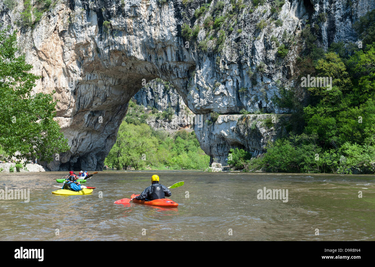 People canoeing on the Ardeche river in the canyon Gorges d'Ardèche near a natural rock bridge near Vallon-Pont-d'Arc, France Stock Photo