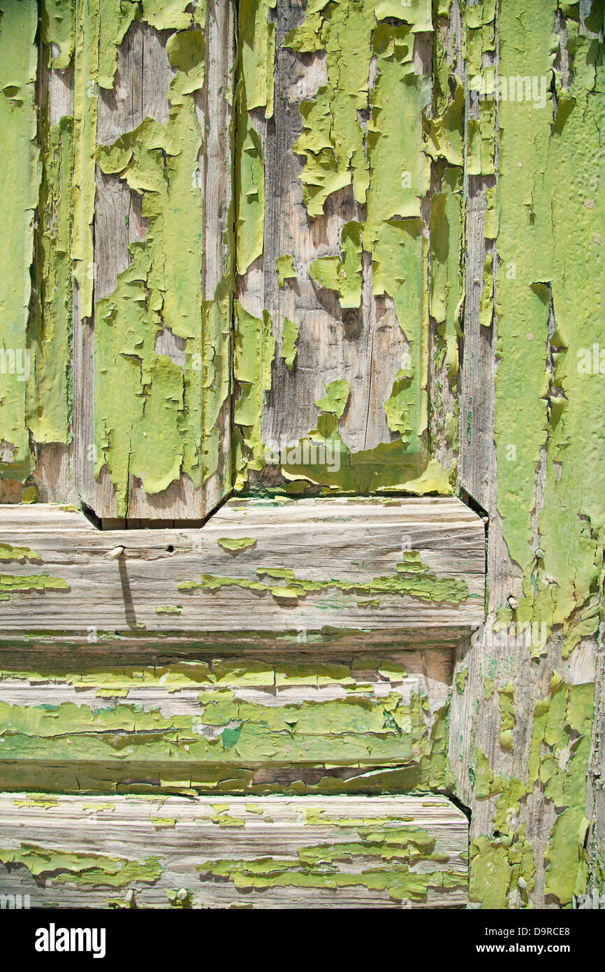 Green paint flakes on a door baking in the sun in Megalochori on the island of Santorini in Greece. Stock Photo