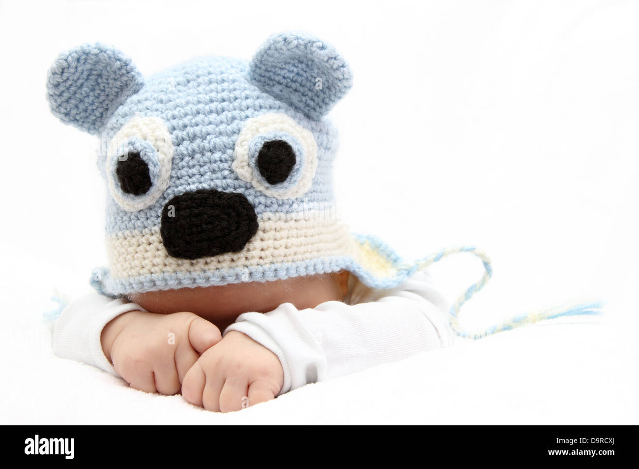 Baby with a knitted blue hat baby on stomach Stock Photo