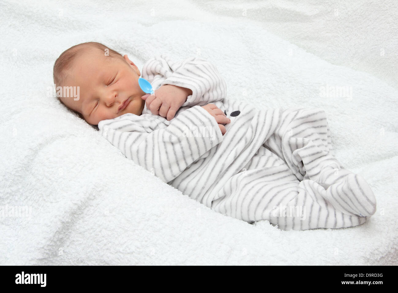 A beautiful sleeping newborn baby with spoon - close up Stock Photo