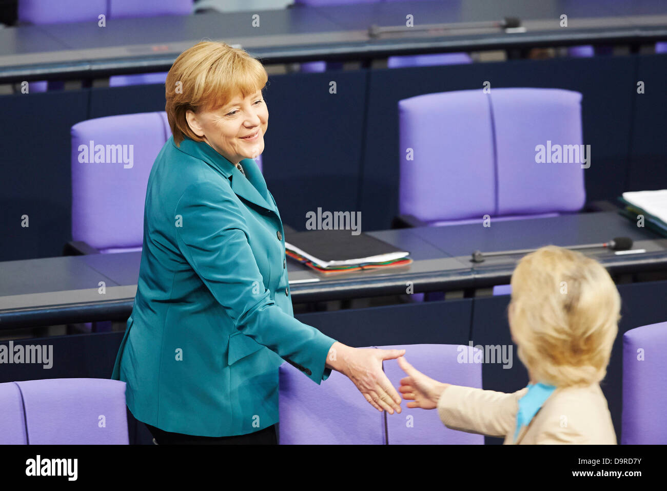 Berlin, Germany. 25th  June, 2013. The Bundestag is holding a special session on 'Helping the victims of the flood misery'. German Chancellor Angela Merkel is giving a government statement on the aids for the vitims of the flood misery providing immediate help and reconstruction. Picture: Handshake between Angela Merkel (CDU), German Chancellor, and Ursula von der Leyen, Federal Minister of Labour and Social Affairs, at Bundestag in beerlin.. Credit:  Reynaldo Chaib Paganelli/Alamy Live News Stock Photo