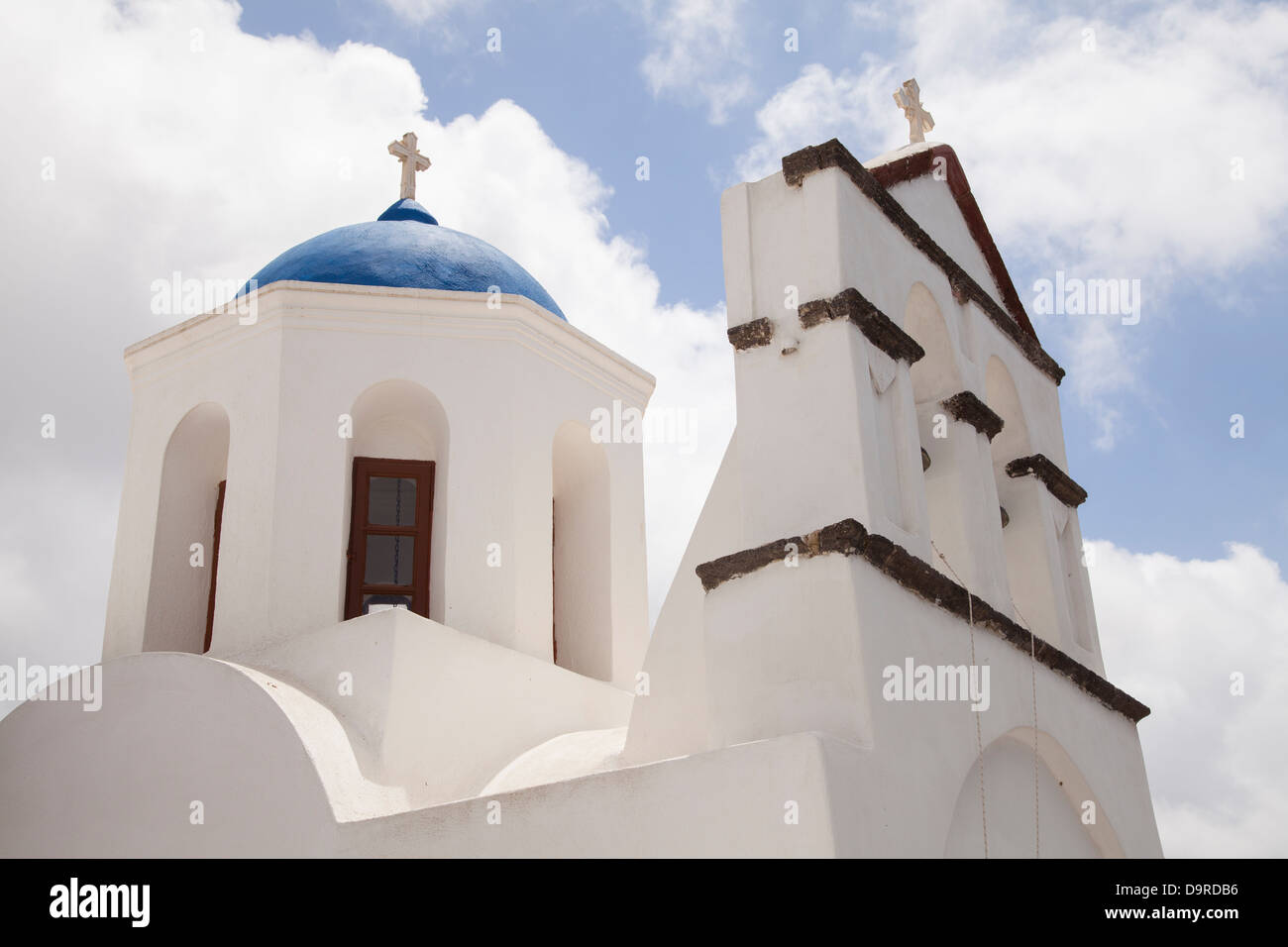 A cycladic blue dome tops a church in the hilltop town of Pyrgos on the island of Santorini in Greece. Stock Photo