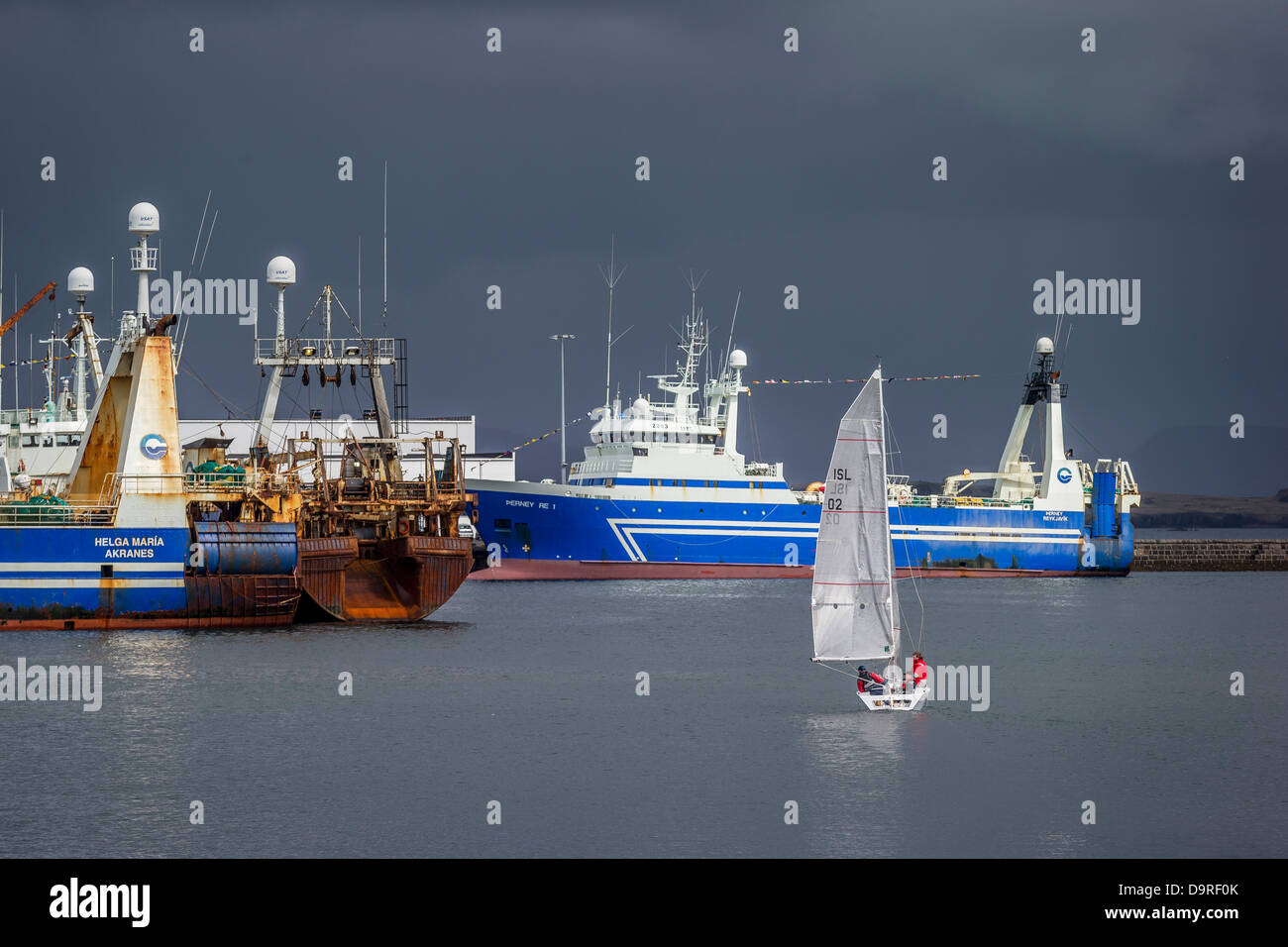 Sailboat and fishing trawlers in Reykjavik Harbor, Iceland Stock Photo