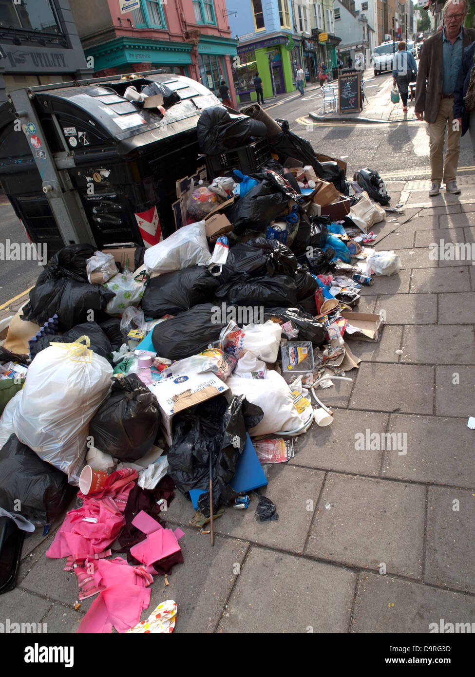 Brighton residents walk past ever growing piles of rubbish on the