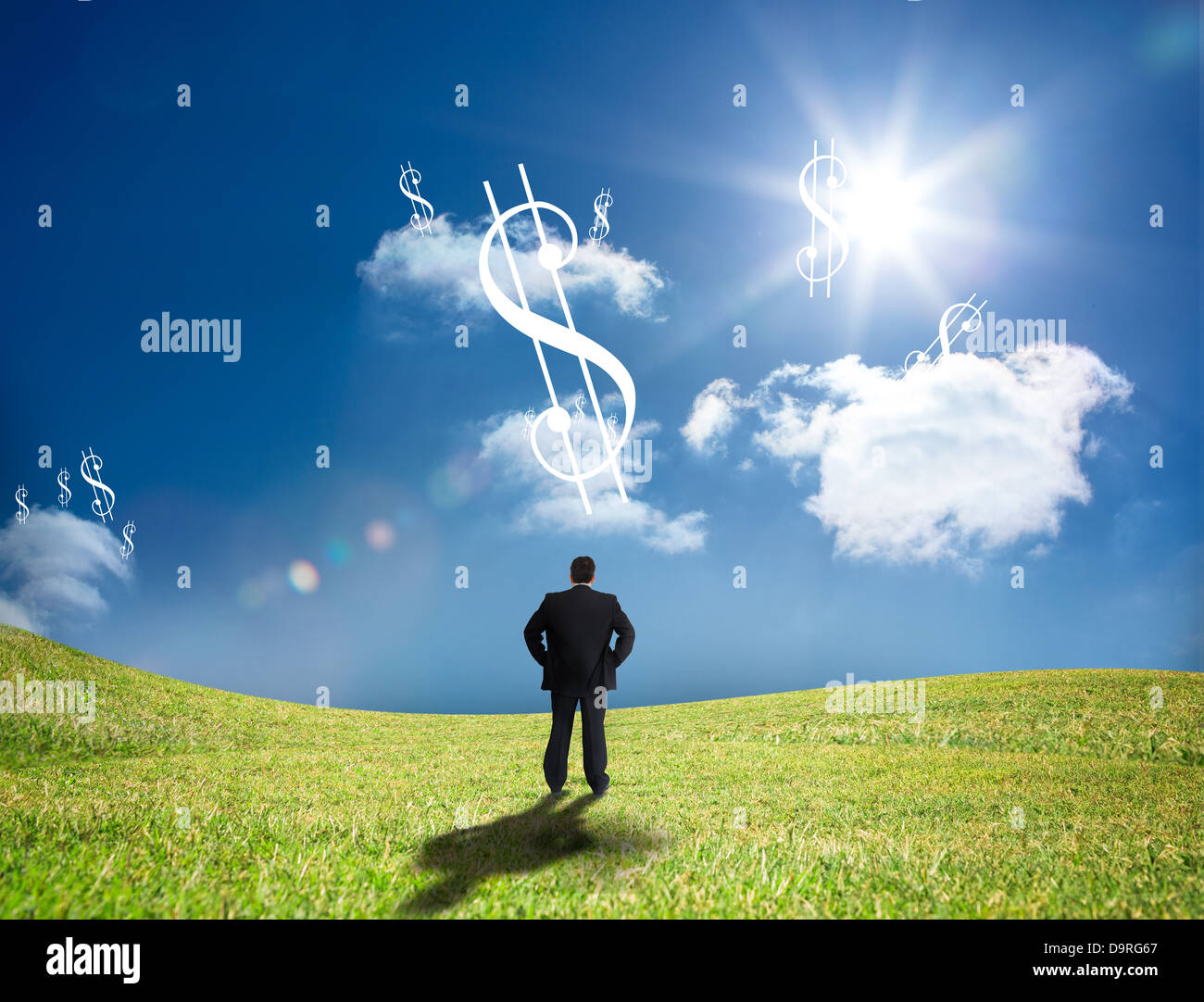 Businessman looking up at dollar signs in the sky Stock Photo
