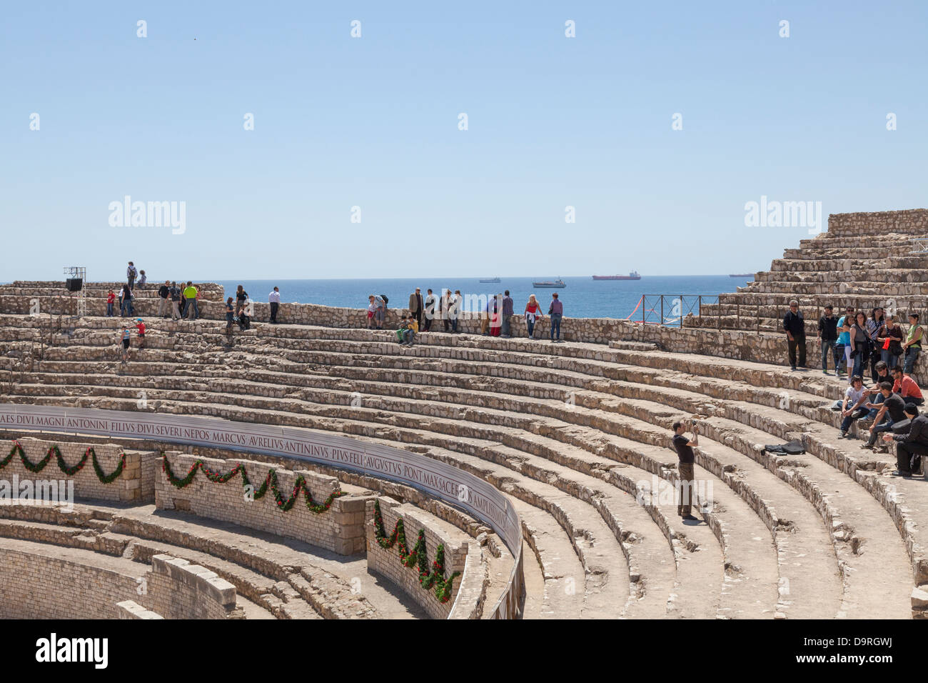 Tourists on seating tiers Roman amphitheatre Tarragona Spain Stock Photo