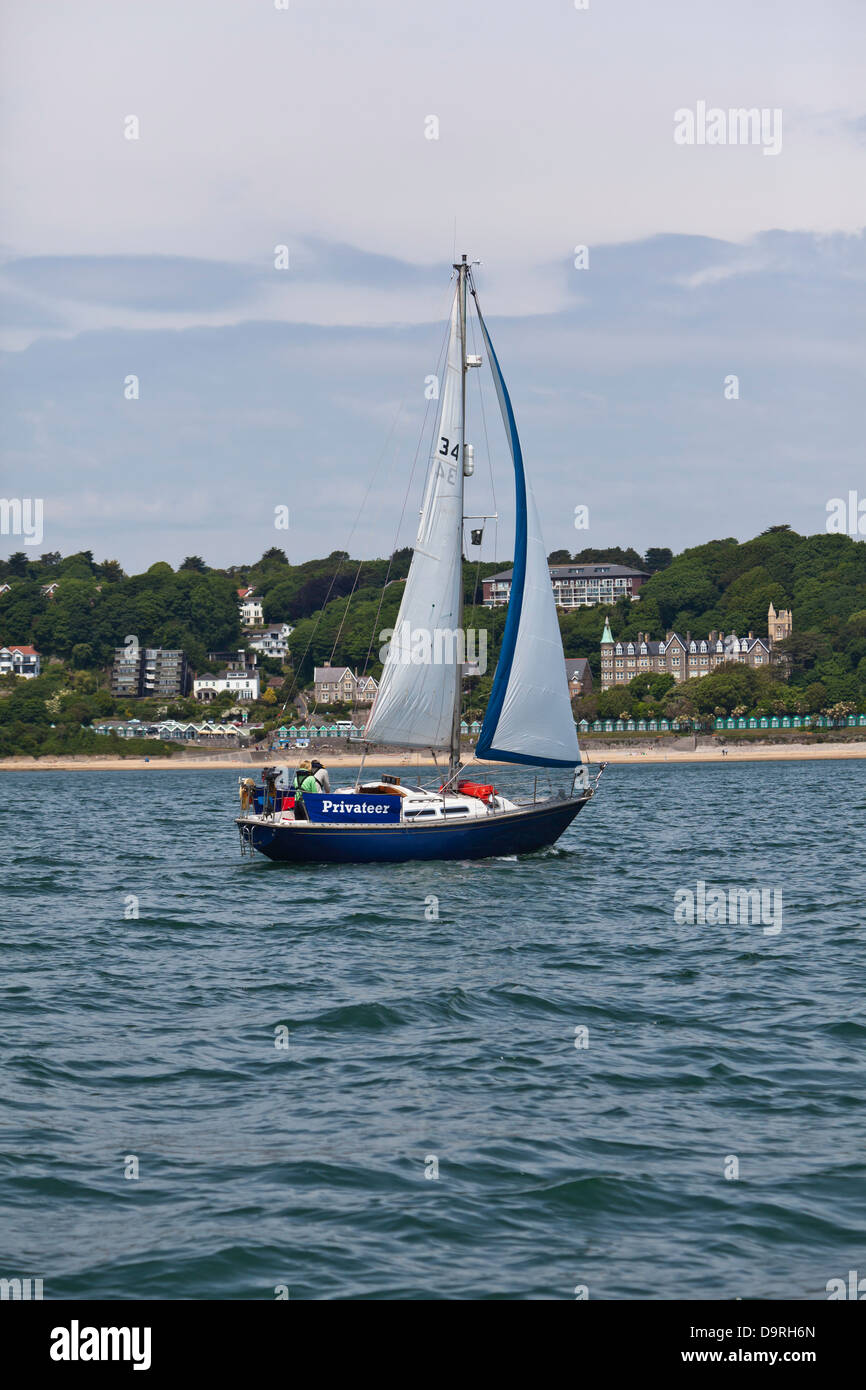 Small yacht in full sail off Langland Bay, south Gower coast, Wales Stock Photo