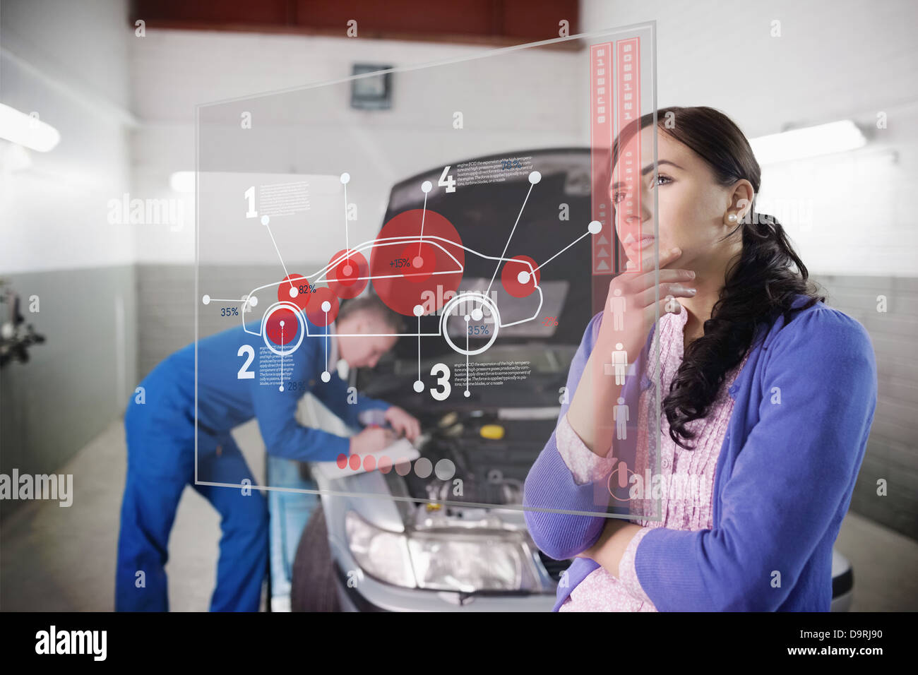 Auto mechanic with customer looking at futuristic interface Stock Photo