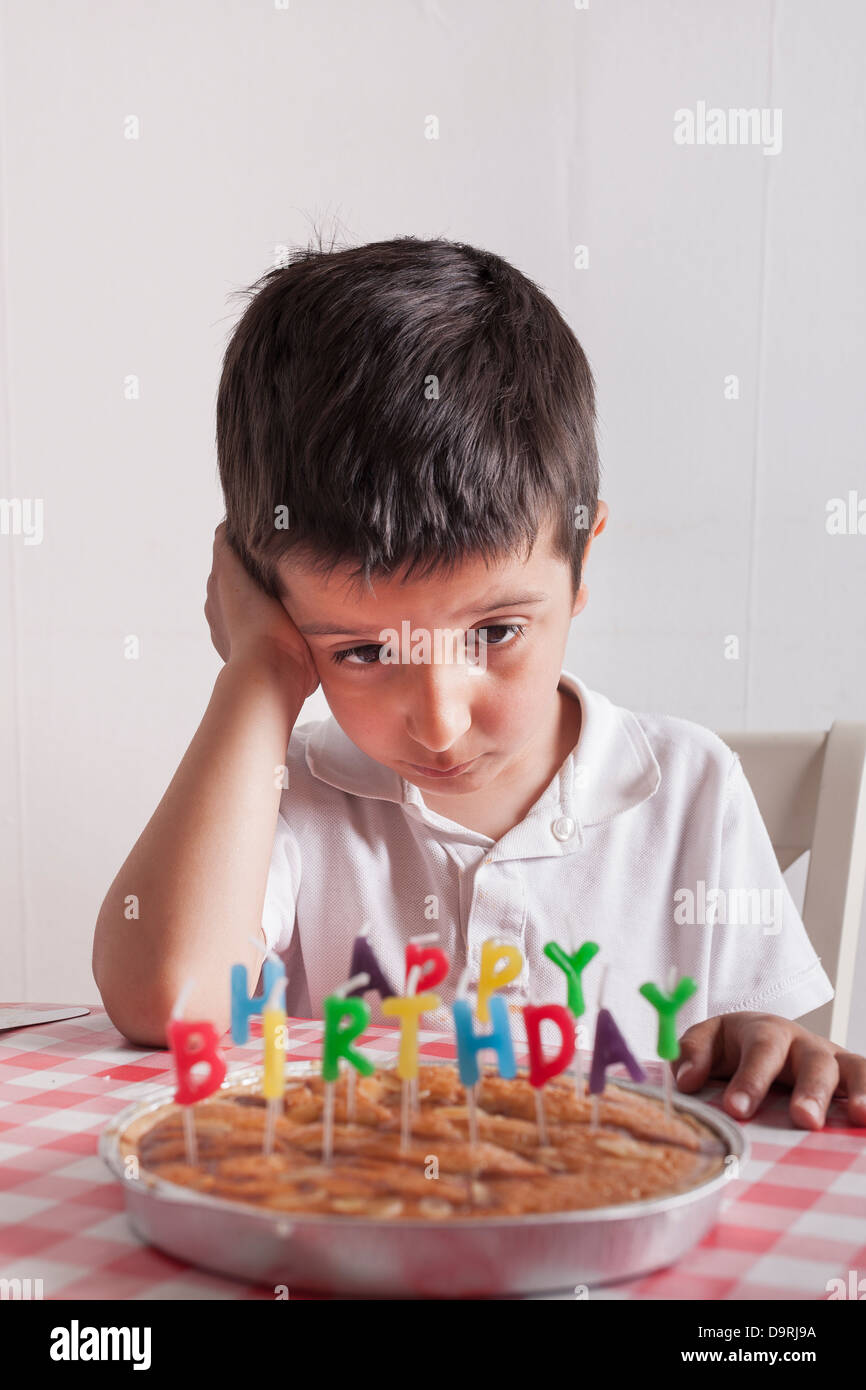 Young boy looking at birthday cake Stock Photo