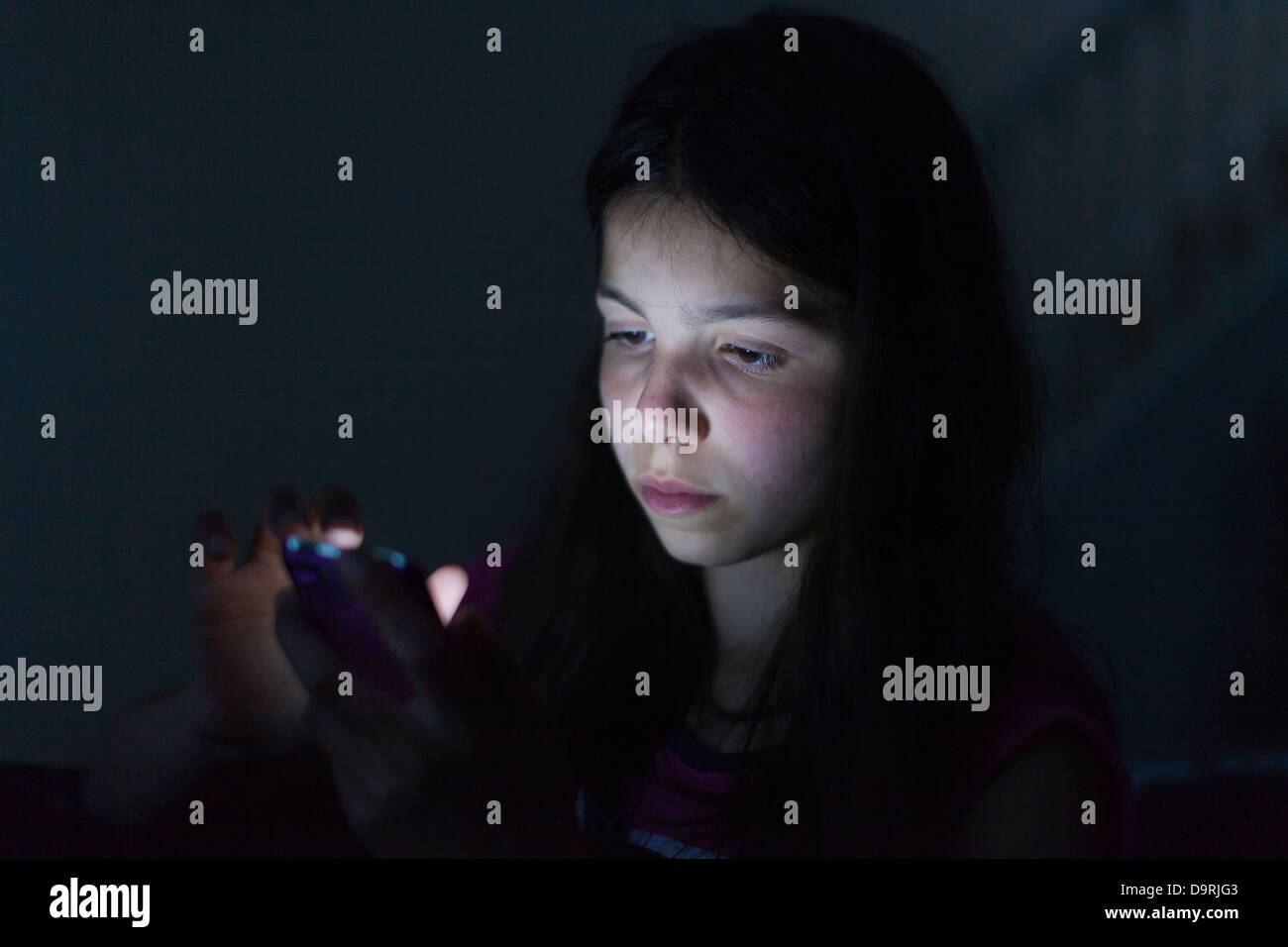 Young girl browses the Internet on a mobile phone Stock Photo