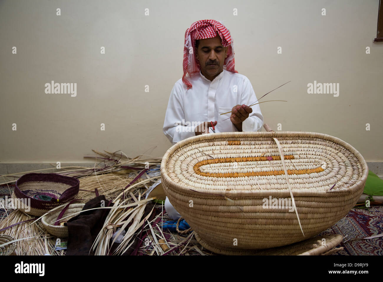 A basket maker demonstrates his skills at the government sponsored Al-Jasara Handicraft Centre in Manama, Bahrain. Stock Photo