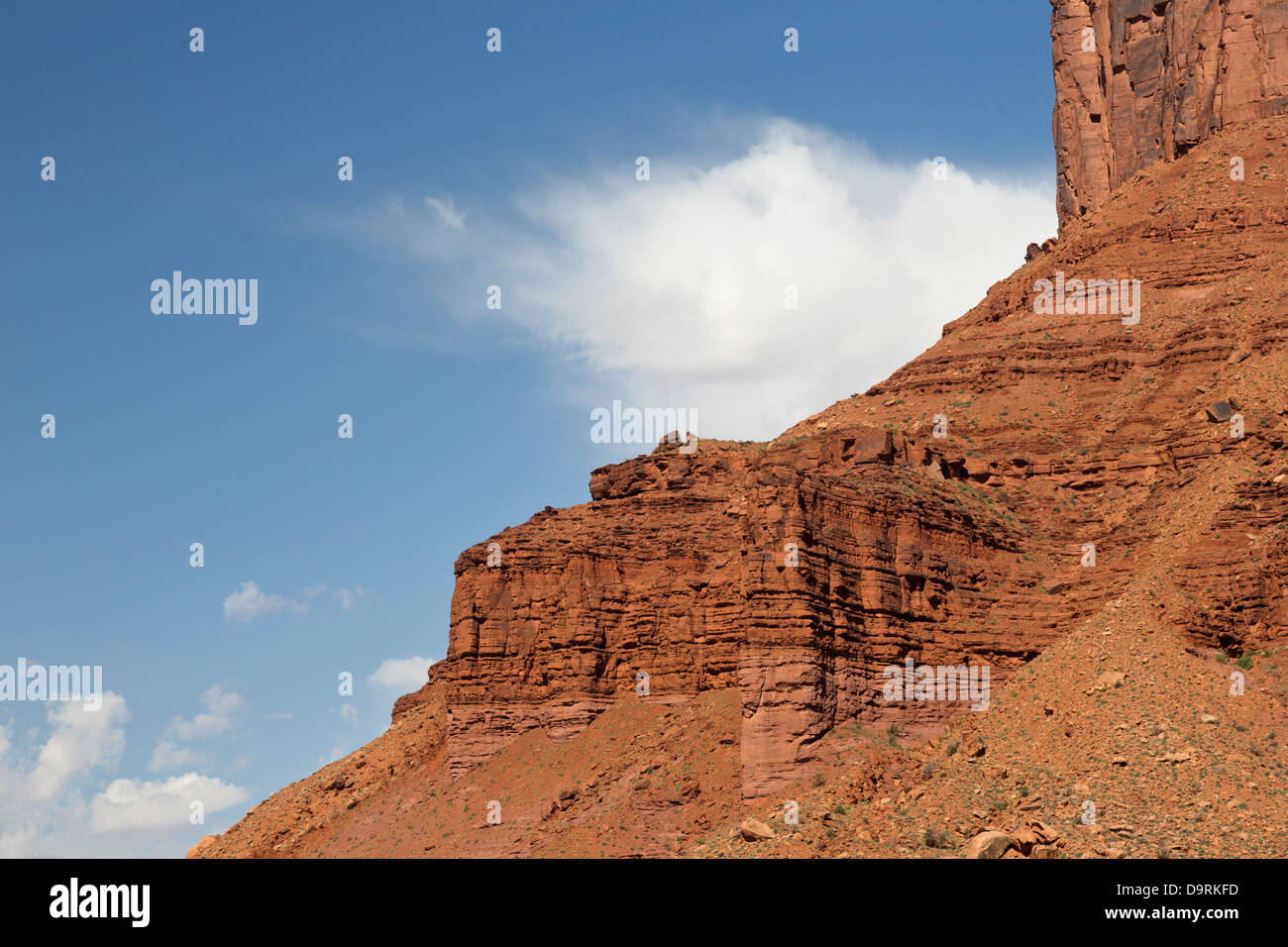 Rugged, sandstone ridges against a blue sky with windswept, white clouds. The La Sal Mountains, south of Moab, Utah. Stock Photo
