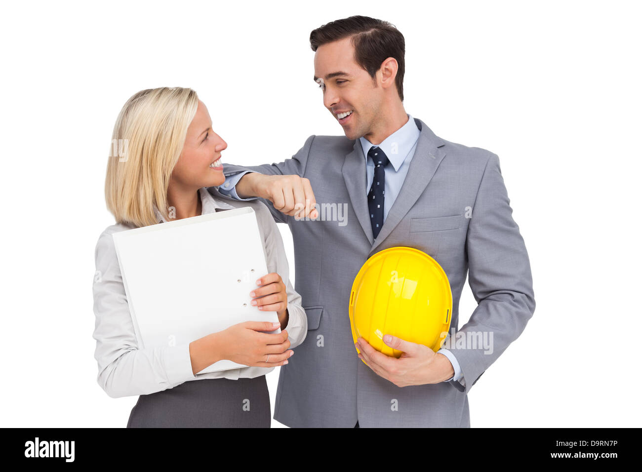 Architects with plans and hard hat smiling at each other Stock Photo