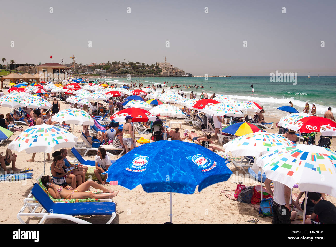 Israel Tel Aviv view of beach towards Jaffa Yafo parasol parasols  sonnenschirm sand sunbathers swimmers loungers crowds bikinis towels Stock  Photo - Alamy