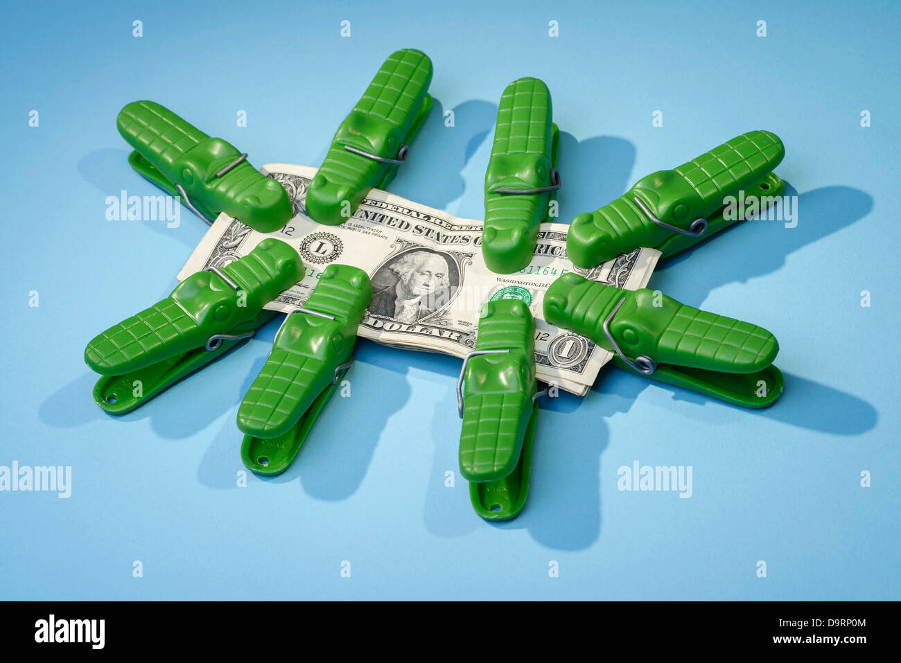 Crocodile clips and dollar bills Stock Photo