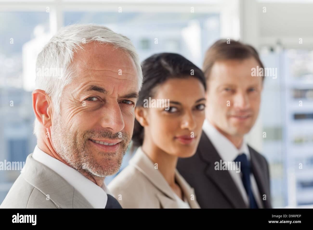 Smiling business people looking in the same way Stock Photo