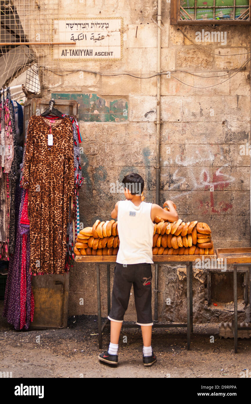 Israel Jerusalem Old City Muslim Arab Quarter stall At Takiyyah Ascent young boy selling bread roll rolls Stock Photo