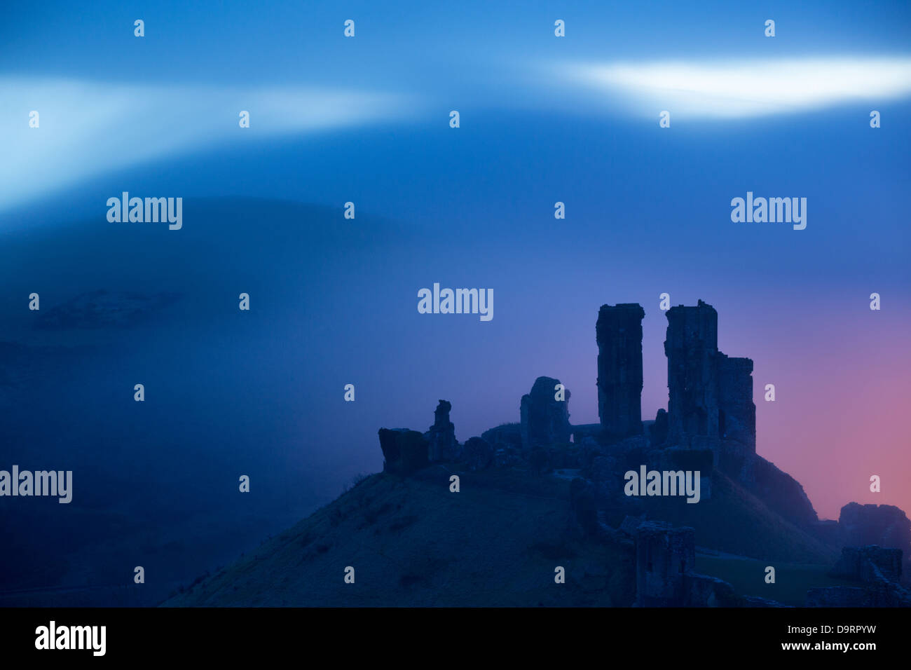Corfe Castle in the mist at dawn, Dorset, England, UK Stock Photo
