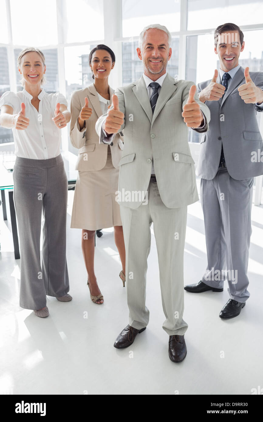 Group of business people giving thumbs up Stock Photo - Alamy