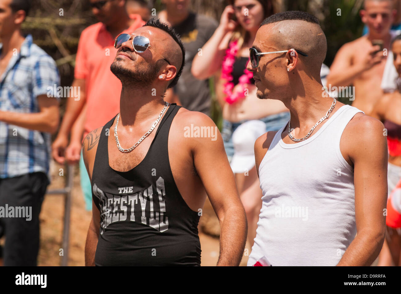 Israel , Tel Aviv , Gay Pride Day parade celebrations 2 two young boys men with shaved heads Mohican hair style & sun glasses Stock Photo