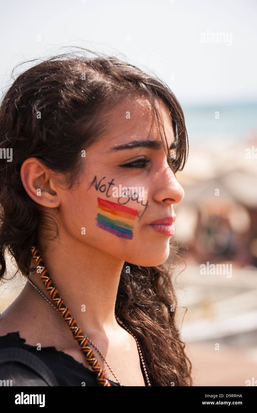 Israel Tel Aviv Gay Pride Day celebrations pretty young girl woman female with not gay & Rainbow LGBT flag on cheek Stock Photo