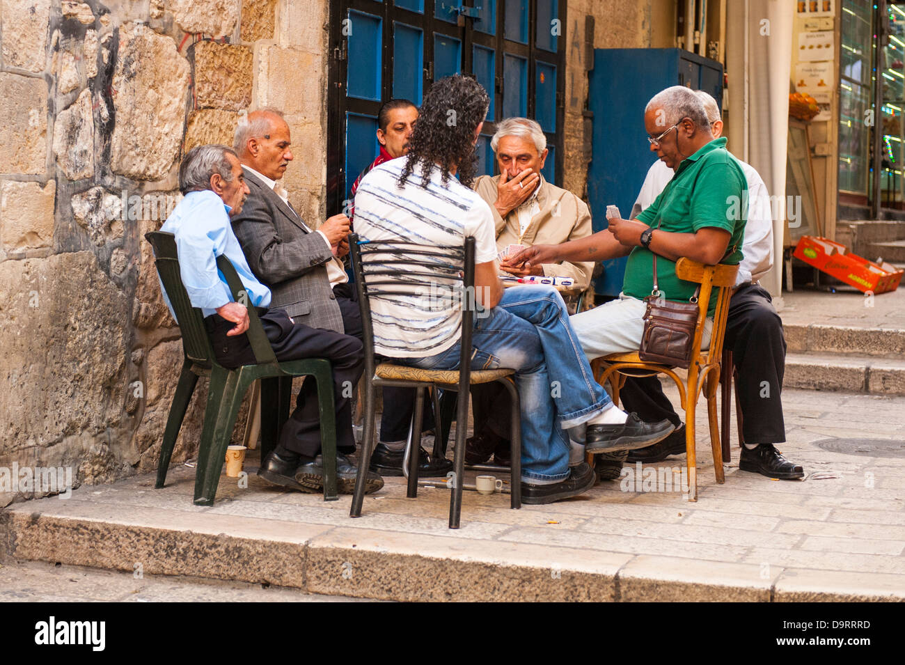 Israel Old City Jerusalem street scene intense group of Arab Muslim men playing cards card game seated around table Stock Photo