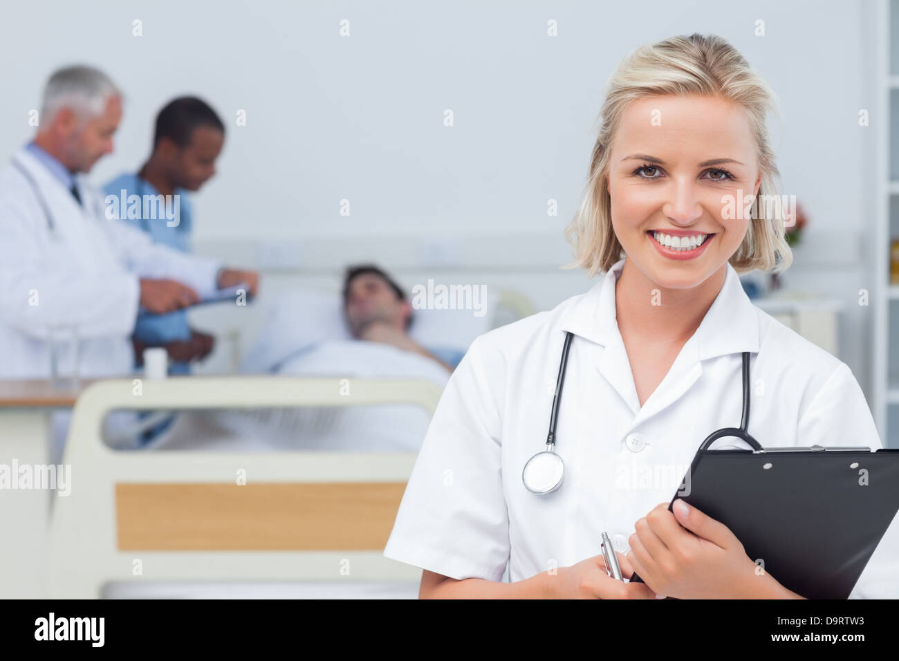 Nurse holding clipboard and looking at the camera Stock Photo - Alamy