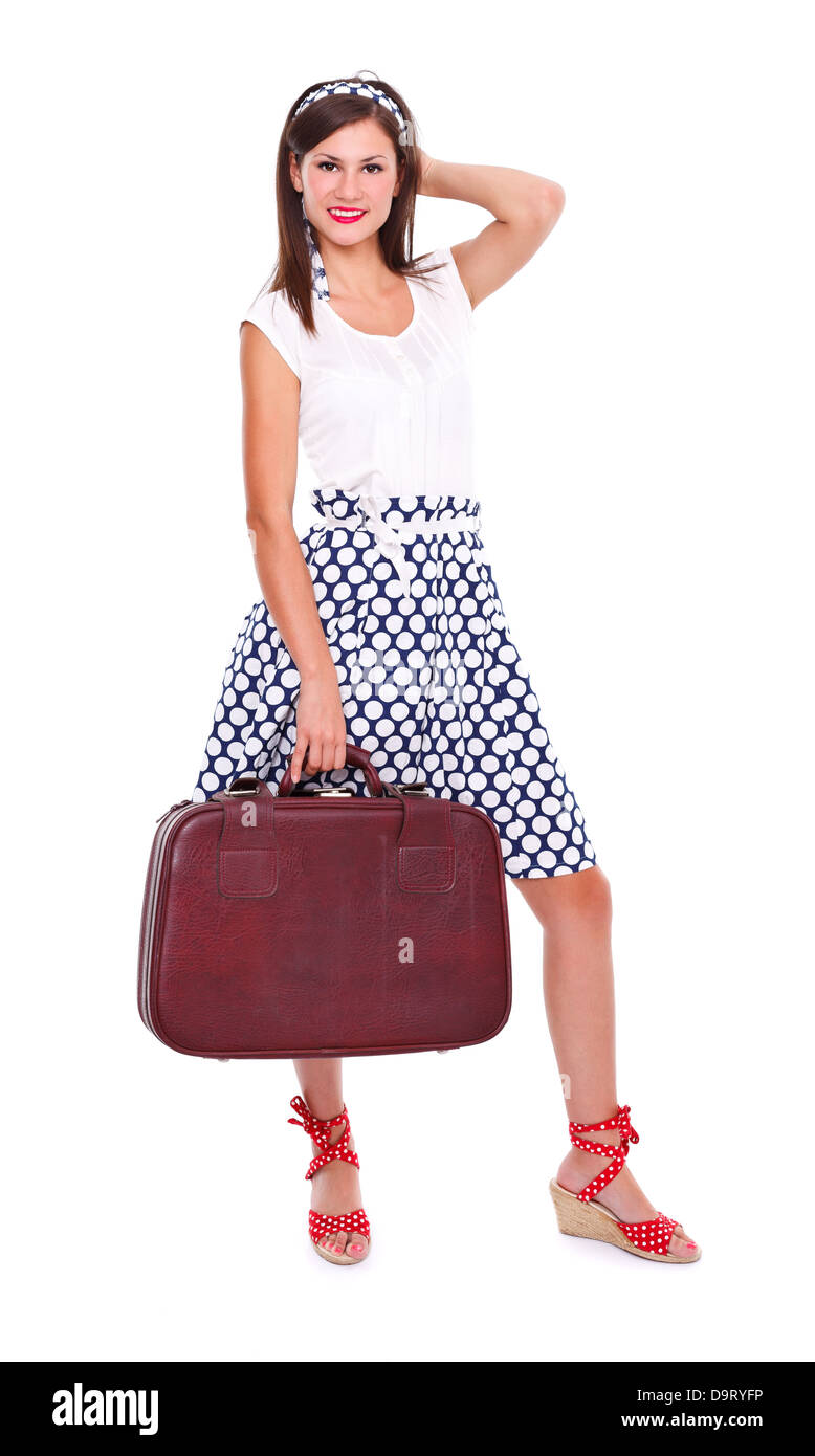 Retro image of a young woman holding a retro suitcase, ready for travel. Isolated. Stock Photo