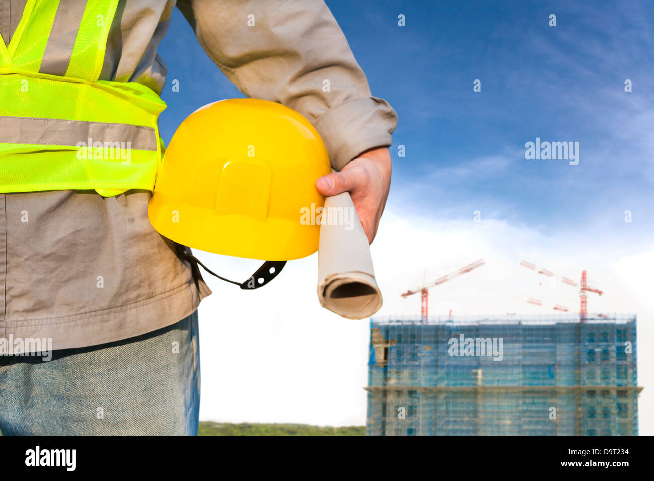 Construction building with worker holding hat Stock Photo