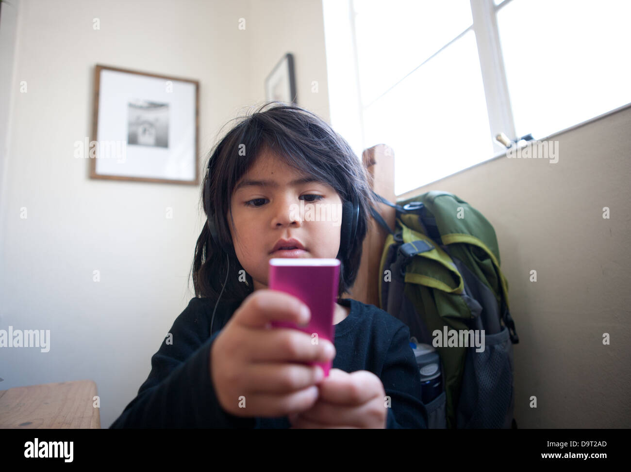 Young girl making a play list of songs on an ipod at home. Stock Photo
