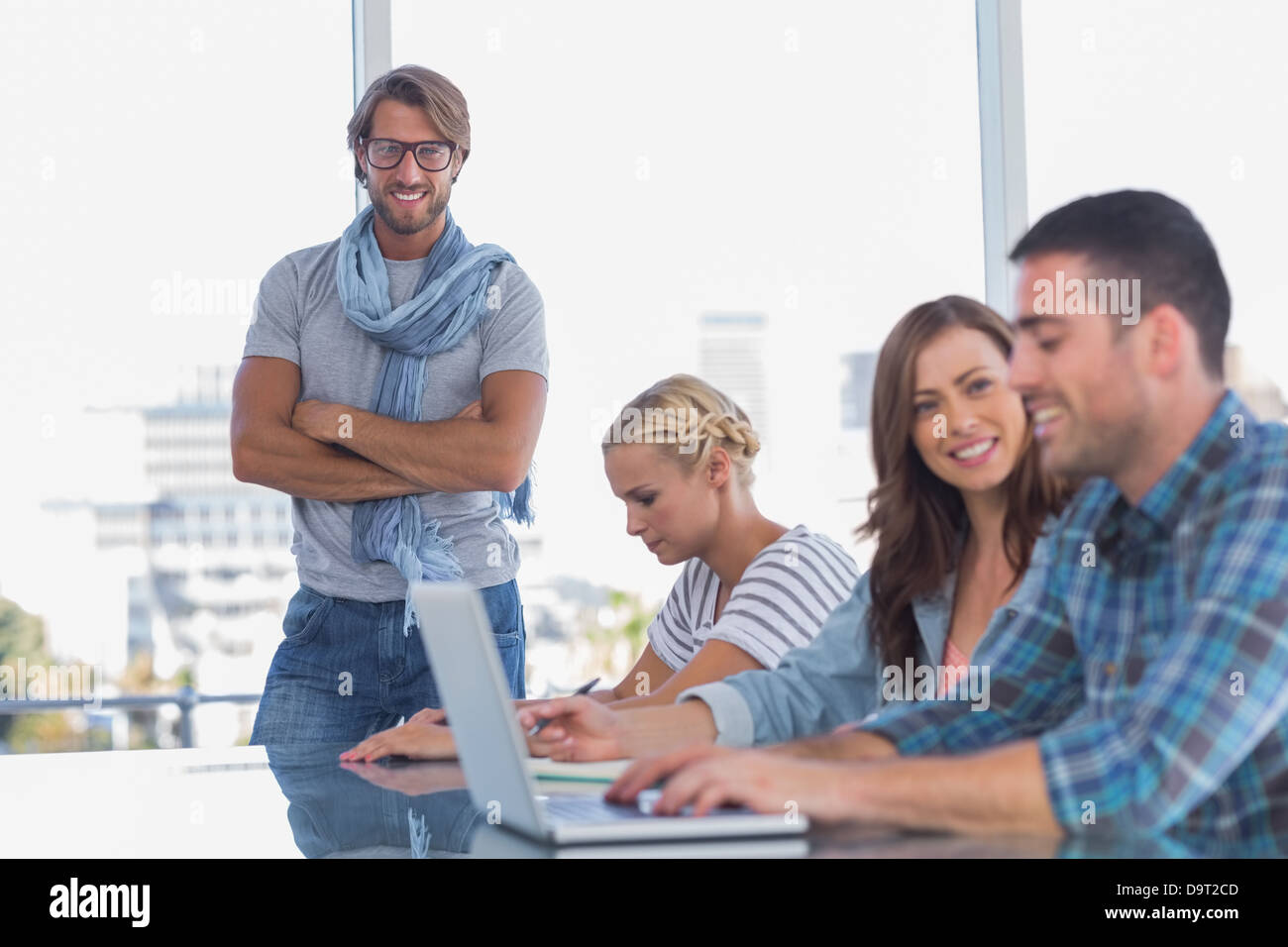 Man standing with arms crossed in creative office Stock Photo - Alamy