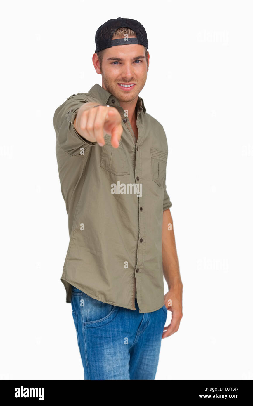 Man smiling and wearing baseball hat backwards and pointing Stock Photo