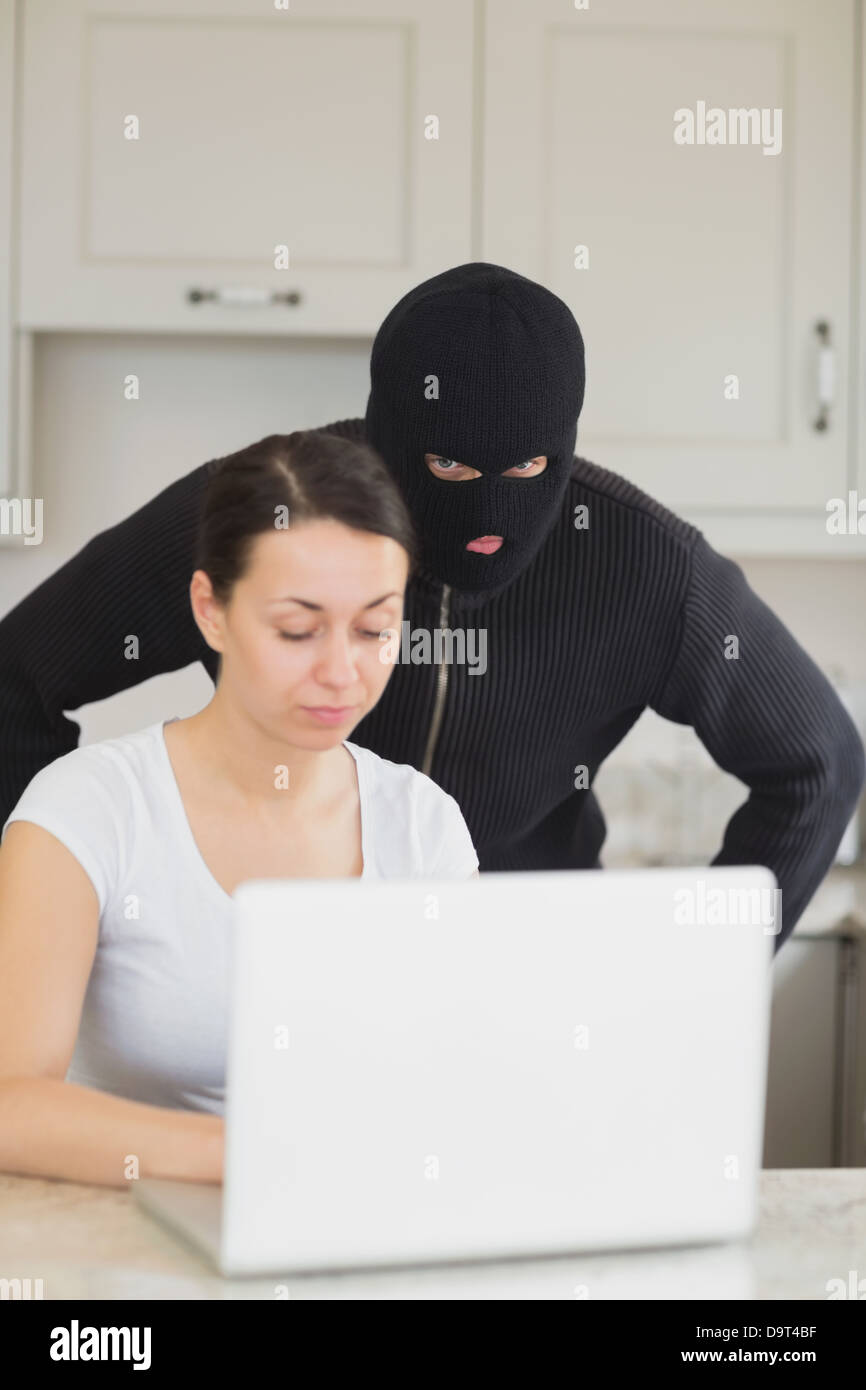 burglar-looking-at-the-laptop-behind-woman-D9T4BF.jpg
