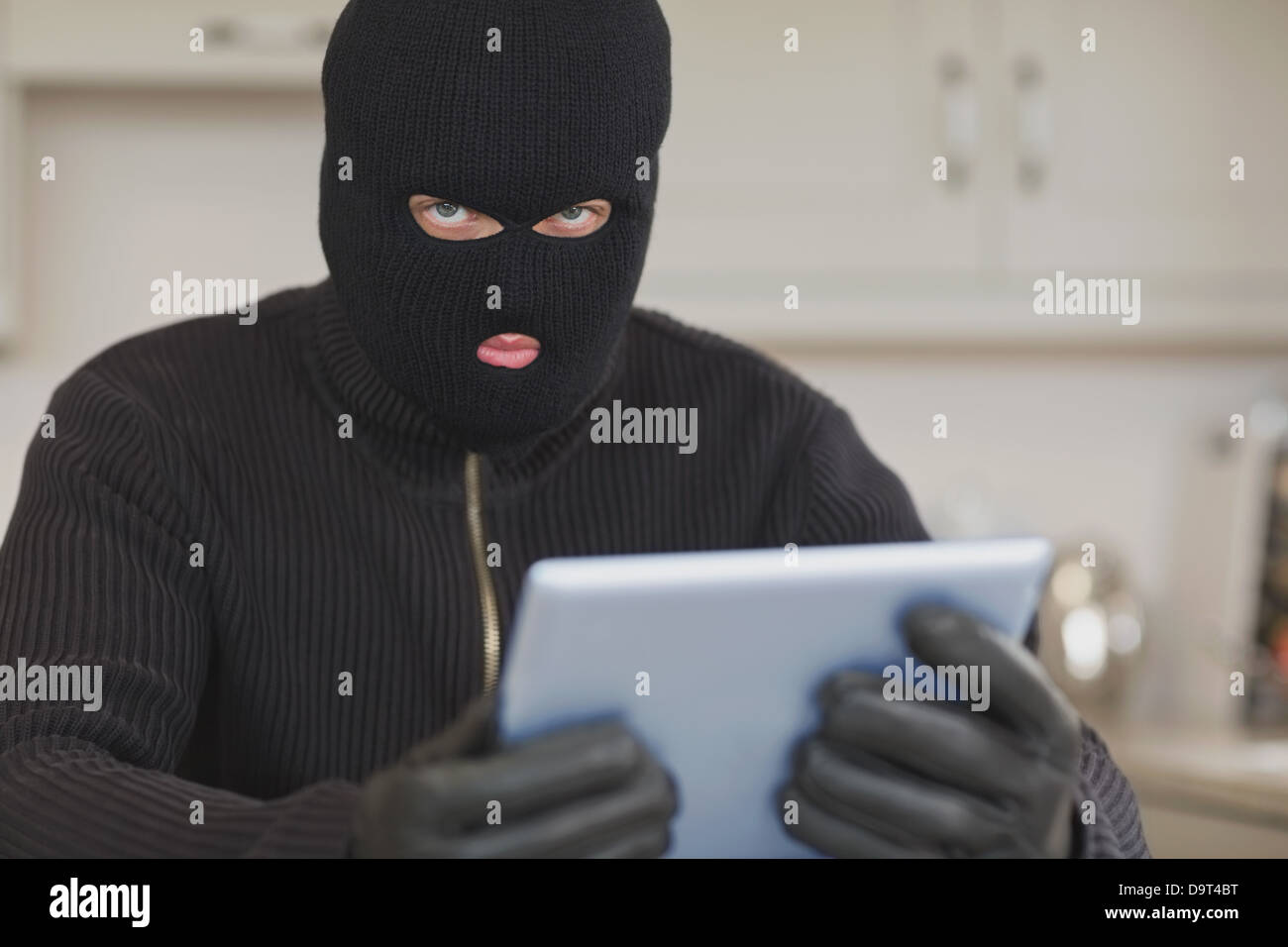 Burglar stealing the tablet pc Stock Photo
