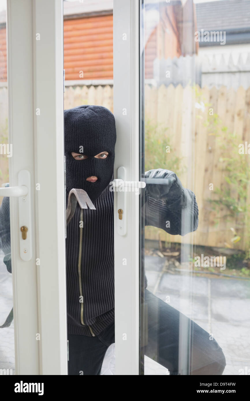 Burglar opening carefully the door Stock Photo