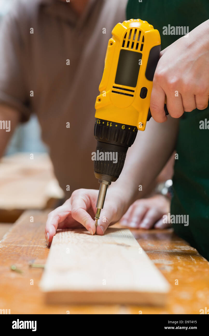 Drilling a hole in a wooden board Stock Photo