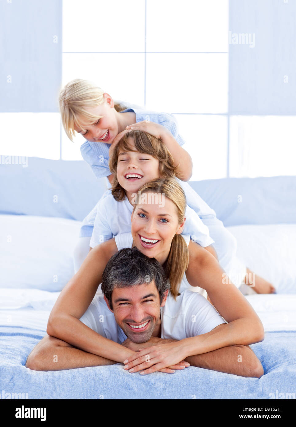 Family piled on top of dad Stock Photo