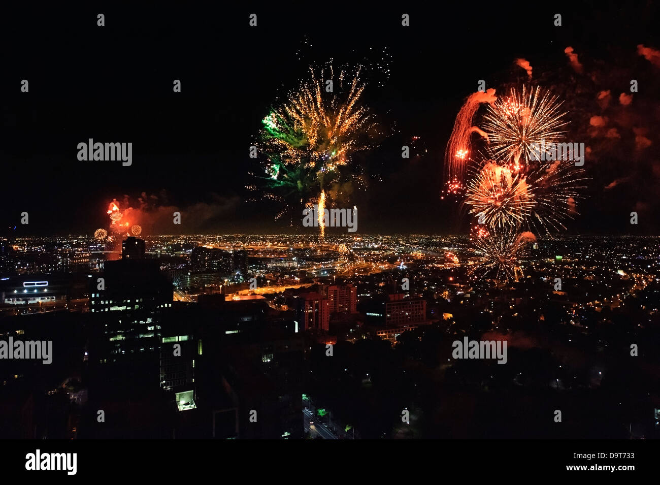 Spectacular fireworks photographed from atop a skyscraper light up the night sky over Melbourne Australia. Stock Photo