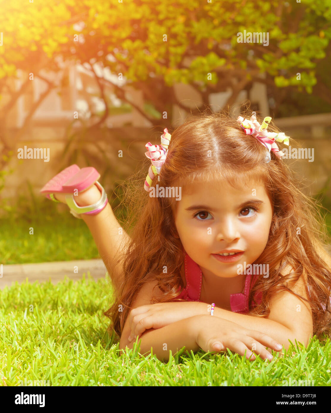 Closeup Portrait Of Cute Arabic Baby Girl Lying Down On Green Grass